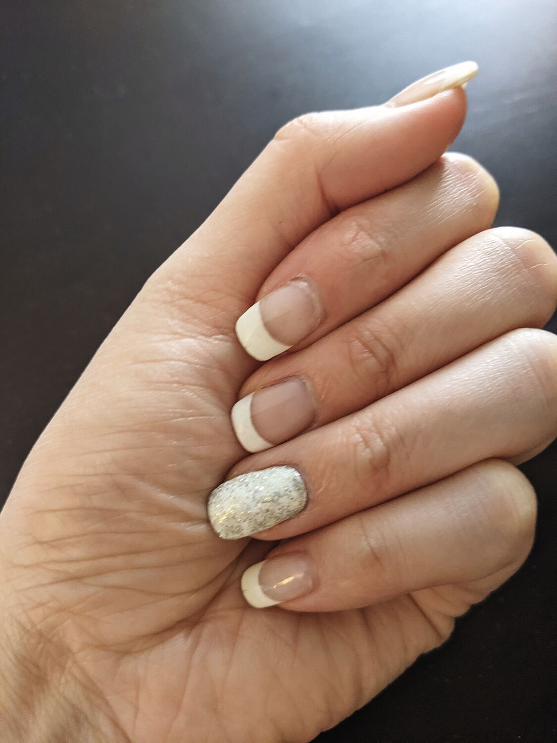 Mão com unhas curtas e verniz claro