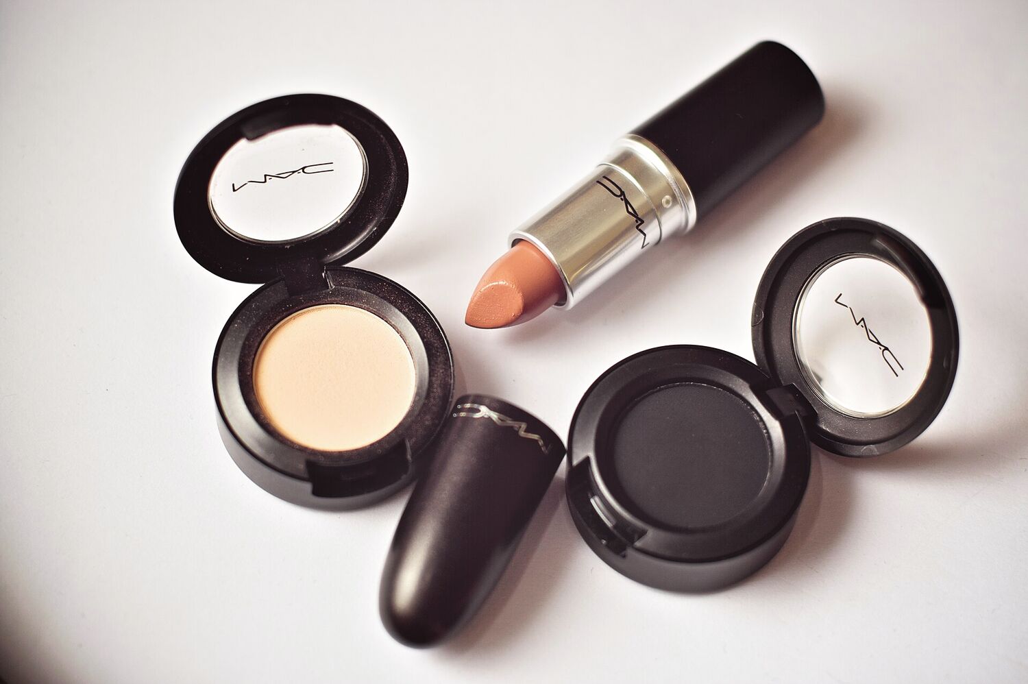 Produtos de maquilhagem abertos sobre superfície clara